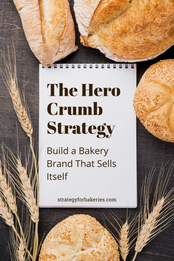 Notebook reading The Hero Crumb Strategy surrounded by bread and wheat, illustrating how to find your bakery signature product.